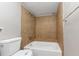 Bathroom featuring a neutral paint, tiled walls in shower tub area and white toilet at 6350 Mozart Dr, Riverdale, GA 30296