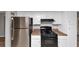 Kitchen boasts stainless steel refrigerator and black gas range, plus white cabinets for ample storage at 6350 Mozart Dr, Riverdale, GA 30296