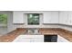 Well-lit kitchen featuring white cabinets, laminate countertops, stainless steel sink and view to the backyard at 6350 Mozart Dr, Riverdale, GA 30296