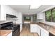 Bright kitchen featuring updated cabinets, stainless steel appliances, durable laminate countertops, and backyard access at 6350 Mozart Dr, Riverdale, GA 30296