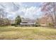 Expansive back of home with multiple decks, fenced yard and view of the lawn and surrounding trees at 210 Little River Farms Trl, Canton, GA 30115