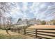 View of home's backyard, featuring a well-maintained lawn, fenced yard, and architectural details of the house at 210 Little River Farms Trl, Canton, GA 30115
