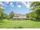 Expansive backyard with a well-maintained lawn, a deck, and patio at 210 Little River Farms Trl, Canton, GA 30115