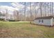Large, wooded backyard with pool, shed, patio, and lawn at 210 Little River Farms Trl, Canton, GA 30115