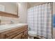 Bathroom featuring a sink with wood cabinets, toilet, and a tub-shower combo with striped curtain at 210 Little River Farms Trl, Canton, GA 30115
