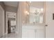 Bathroom showcasing a vanity with marble countertop, decorative lighting, and a glimpse into an adjoining room at 210 Little River Farms Trl, Canton, GA 30115
