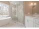 Elegant bathroom boasting a glass-enclosed shower with rain showerhead and a marble-topped vanity with white cabinets at 210 Little River Farms Trl, Canton, GA 30115