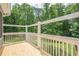 View of wood deck overlooking a lush green lawn and tall trees at 210 Little River Farms Trl, Canton, GA 30115