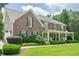 Beautiful two-story brick home with well-maintained landscaping, garage with a basketball hoop, and a welcoming front porch at 210 Little River Farms Trl, Canton, GA 30115