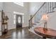 Elegant foyer with hardwood floors, staircase, and decorative front door at 210 Little River Farms Trl, Canton, GA 30115