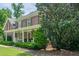 Charming brick home with covered porch, rocking chairs, and manicured landscaping at 210 Little River Farms Trl, Canton, GA 30115