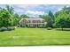 Beautiful two-story brick home with a well-manicured lawn and mature trees at 210 Little River Farms Trl, Canton, GA 30115