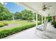 Covered front porch with rocking chairs overlooking lush green lawn and mature trees at 210 Little River Farms Trl, Canton, GA 30115