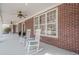 Inviting brick front porch with classic rocking chairs and ample natural light at 210 Little River Farms Trl, Canton, GA 30115