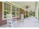 Spacious covered front porch with rocking chairs, ceiling fans, and classic brick accents at 210 Little River Farms Trl, Canton, GA 30115
