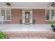 Charming front porch featuring a brick facade and decorative planters at 210 Little River Farms Trl, Canton, GA 30115