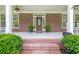 Charming covered front porch featuring brick steps, potted ferns, and a beautiful front door at 210 Little River Farms Trl, Canton, GA 30115