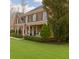 Charming brick home with a covered front porch, lush green lawn, and mature landscaping at 210 Little River Farms Trl, Canton, GA 30115