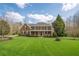 Inviting brick home featuring a large lawn, covered porch, and classic architectural details at 210 Little River Farms Trl, Canton, GA 30115