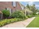 All brick home with mature landscaping, flowering bushes, and a charming, covered porch at 210 Little River Farms Trl, Canton, GA 30115