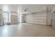 Spacious garage with neutral colored epoxy flooring, plenty of storage space, and a large garage door at 210 Little River Farms Trl, Canton, GA 30115