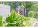 Lush green garden with yellow flowers and a black fence at 210 Little River Farms Trl, Canton, GA 30115