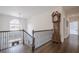 Hallway with dark hardwood floors, ornate railings, and large window for natural light at 210 Little River Farms Trl, Canton, GA 30115