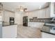 Bright kitchen features white cabinets, granite counters, stainless appliances, and tiled backsplash at 210 Little River Farms Trl, Canton, GA 30115