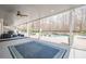 A covered stone patio offers pool views and features an area rug, lounge furniture and ceiling fans at 210 Little River Farms Trl, Canton, GA 30115