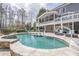 Backyard pool area with comfortable seating and mature landscaping, perfect for relaxation and entertaining at 210 Little River Farms Trl, Canton, GA 30115