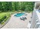 Aerial view of a kidney-shaped pool with lounge chairs surrounded by trees and landscaped gardens at 210 Little River Farms Trl, Canton, GA 30115