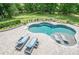 Kidney shaped pool with lounge chairs and landscaped backyard at 210 Little River Farms Trl, Canton, GA 30115
