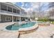 An in-ground kidney-shaped pool with tanning ledges is surrounded by gray home and lounge furniture at 210 Little River Farms Trl, Canton, GA 30115