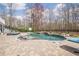 Stunning in-ground pool with stone accents, lounge chairs, and a serene backyard setting at 210 Little River Farms Trl, Canton, GA 30115