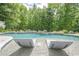 Close-up of the pool featuring submerged loungers, crystal-clear water, and a lush green backdrop at 210 Little River Farms Trl, Canton, GA 30115