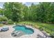 Inviting backyard pool with sun loungers, lush landscaping, and a serene wooded backdrop at 210 Little River Farms Trl, Canton, GA 30115