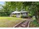 Charming home with a beautifully landscaped front yard and a stone pathway, nestled among mature trees at 2343 Poplar Springs Ne Dr, Brookhaven, GA 30319