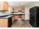 Functional kitchen features wood cabinets, black appliances and wood-look vinyl flooring at 2743 High Tide Dr, Atlanta, GA 30349