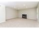 Cozy living room with a fireplace, plush carpet, and bright, natural light streaming through the window at 2743 High Tide Dr, Atlanta, GA 30349