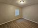 Bedroom with wood-look flooring, neutral colored walls, and a light fixture at 2860 Cocklebur Cove Ct, Decatur, GA 30034