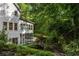 Lush backyard landscaping with stone walkway and exterior of a white home with screened-in porch at 1260 Heards Ferry Rd, Sandy Springs, GA 30328