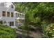 Lush backyard landscaping with stone walkway and exterior of a white home with screened-in porch at 1260 Heards Ferry Rd, Sandy Springs, GA 30328