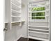 Walk-in closet with custom shelving, window and hardwood floor at 1260 Heards Ferry Rd, Sandy Springs, GA 30328