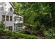 A two-story home nestled in the woods with mature landscaping and a stone pathway at 1260 Heards Ferry Rd, Sandy Springs, GA 30328