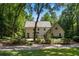 Inviting two-story home featuring a light-colored exterior, mature trees and a charming landscaped yard at 1260 Heards Ferry Rd, Sandy Springs, GA 30328