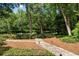 View of the stone path leading up to the home surrounded by lush trees and manicured greenery at 1260 Heards Ferry Rd, Sandy Springs, GA 30328