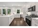 A spacious eat-in kitchen features stainless appliances, white cabinetry, and breakfast bar seating at 1260 Heards Ferry Rd, Sandy Springs, GA 30328