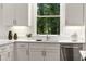 A kitchen featuring white cabinets and quartz countertops overlooks a wooded backyard at 1260 Heards Ferry Rd, Sandy Springs, GA 30328