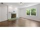 Bright living room with green tile fireplace, large window, and hardwood floors at 1260 Heards Ferry Rd, Sandy Springs, GA 30328