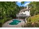 Beautiful backyard with a kidney-shaped pool, patio, and white home exterior surrounded by trees at 1260 Heards Ferry Rd, Sandy Springs, GA 30328
